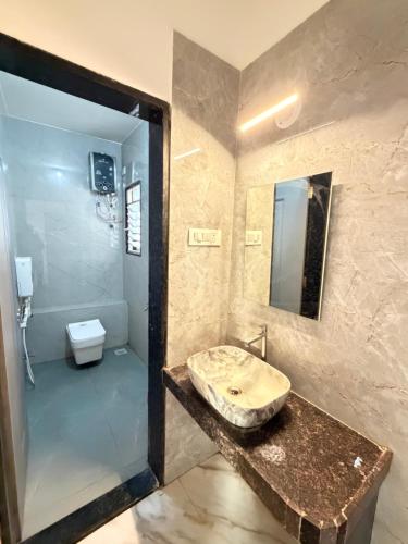 a bathroom with a sink and a toilet at Gurukrupa Yatri Nivas in Kolhapur