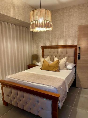 a bedroom with a large bed and a chandelier at Villa Divina in Punta Cana