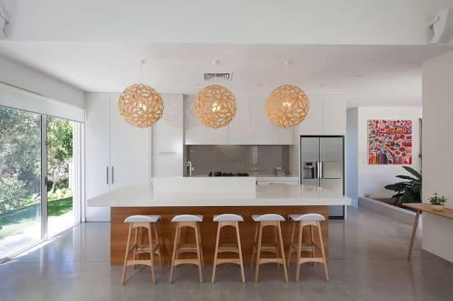 a kitchen with a island with bar stools at White Sands Beach House in Marcoola