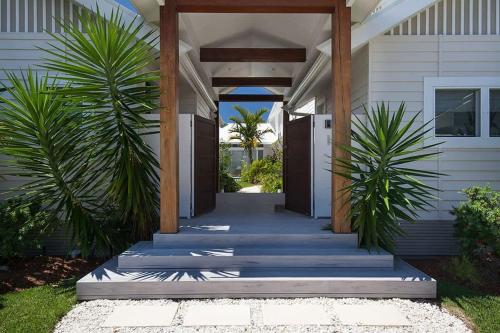 a hallway leading to a house with palm trees at White Sands Beach House in Marcoola