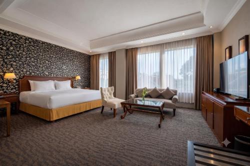 a hotel room with a bed and a flat screen tv at The Mirah Hotel Bogor in Bogor