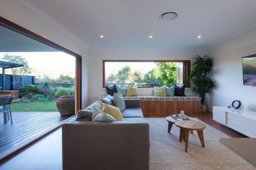 a living room with a couch and a large window at Green House in Marcoola