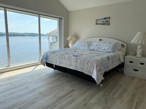 a bedroom with a bed with a view of the water at Spacious Lakeview Condo with 3 BR3 BA and Pool in Lake Ozark