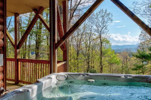 a hot tub in a cabin with a view of the mountains at Chestnut Lodge in Boone