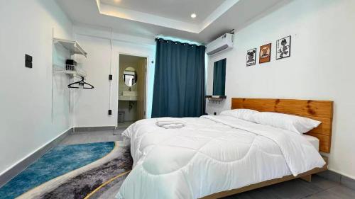 a bedroom with a large white bed and a blue rug at Villa Wongamat in North Pattaya