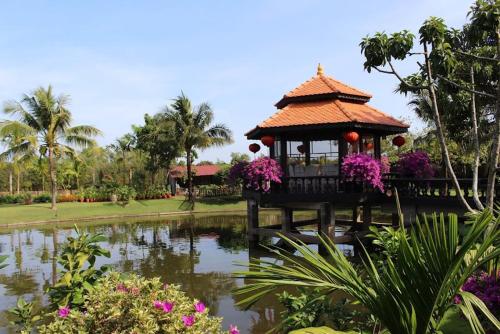 a gazebo over a pond in a park at Woods House Homestay in Sa Ðéc