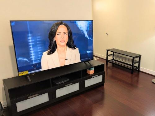 a large flat screen tv sitting on a entertainment center at Silicon Valley Stays Casa Dos in Mountain View