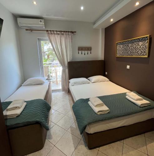 a bedroom with two beds and a window at Grecian Sea in Limenaria