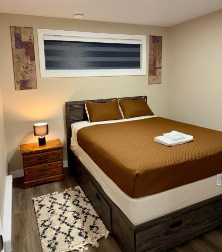 a bedroom with a bed and a window and a table at Modern Private Suite, Cozy, Stylish & Spacious in Regina