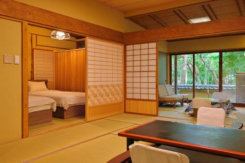 a room with a bedroom with a bed and a table at 三平荘 in Atami