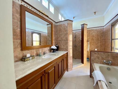 a bathroom with a large tub and a sink and a tub at Bali Emerald Villas in Sanur