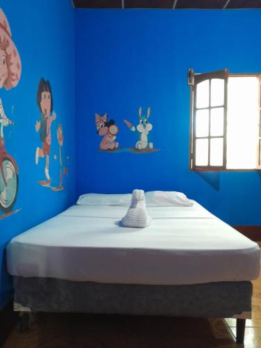 a bedroom with a blue wall with a bed at CASA MARCELa in Altagracia