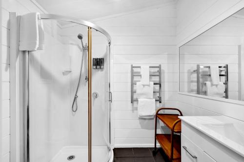 a white bathroom with a shower and a sink at Island view Experience in Coromandel Town