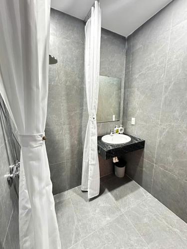 a bathroom with a sink and a shower curtain at LAA Maison in Hoi An