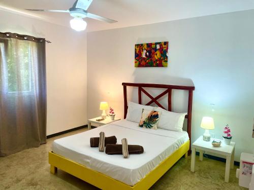 a bedroom with a bed with two shoes on it at Villa KAMBUSA in Las Galeras