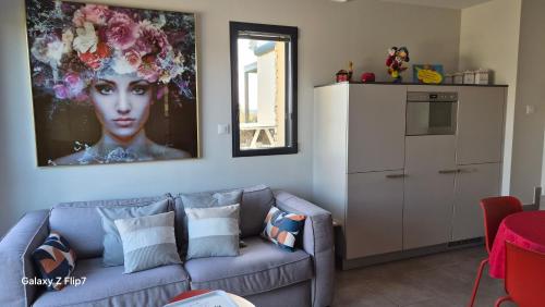 a living room with a couch and a painting on the wall at AU GRAIN D'ORGE in Échiré