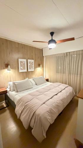 a large bed in a bedroom with a ceiling fan at Puerta Azul in Punta del Este