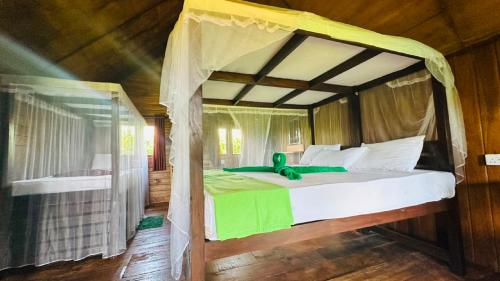 a bedroom with a large bed with a canopy at Elegant Elephant Tree House Sigiiriya in Sigiriya