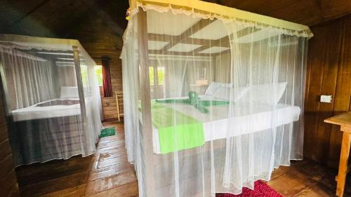 a bedroom with a bed and a window with curtains at Elegant Elephant Tree House Sigiiriya in Sigiriya