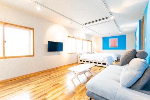 a living room with a couch and a bed at Hotel Beach-House in Otsu