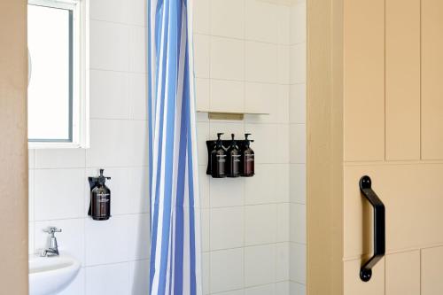 a bathroom with a shower curtain and a sink at Chalet Motel Brunswick Heads in Brunswick Heads
