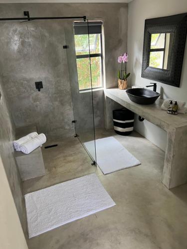 a bathroom with a glass shower and a sink at Market on 5 in Piet Retief