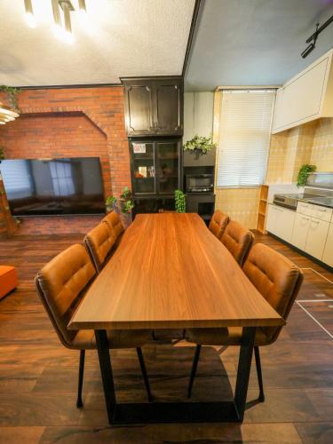 ein großer Holztisch in einer Küche mit Lederstühlen in der Unterkunft E E House in Numazu