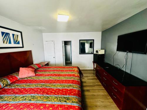 a bedroom with a bed and a flat screen tv at San Clemente Surf Inn in San Clemente