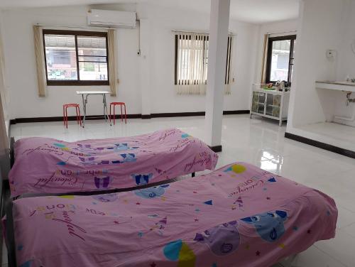 two beds in a room with pink sheets at Jr - House 2 34-103 in Ban Talat Rangsit