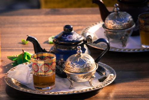 a tea set on a plate with a tea pot and a cup at Imsouane petitsurfer SurfCamp & Yoga in Imsouane