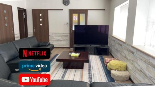 a living room with a couch and a tv at サンライズ日南 in Nichinan