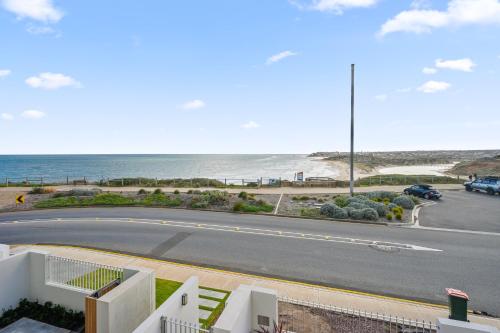 a view of a road with the ocean in the background at Meander - Port Noarlunga South - C21 SouthCoast Holidays in Port Noarlunga South