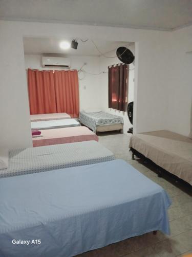a group of beds in a room at Pousada central Russana in Russas