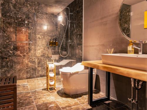 a bathroom with a toilet and a sink at Shakespeare Hotel in Hakuba