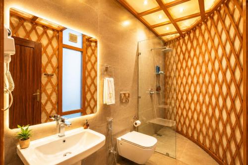 a bathroom with a sink and a toilet and a shower at Bel-La Monde Riverside Jim Corbett - "A Unit of Luxe Opera Hotels & Resorts" in Garjia