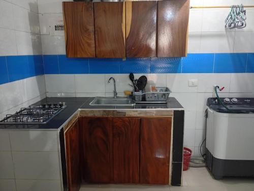 a kitchen with a sink and a stove at Hospedaje Meriland in Guayabal