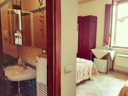 a bathroom with a sink and a bed at Agriturismo Il Piastrino in Vinci