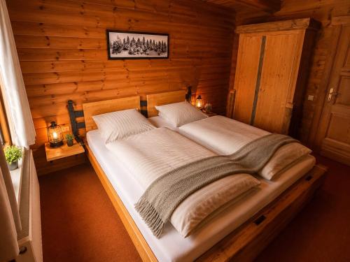 a bedroom with a large bed in a wooden room at Ferienwohnungen Forellengrund Schierke in Schierke