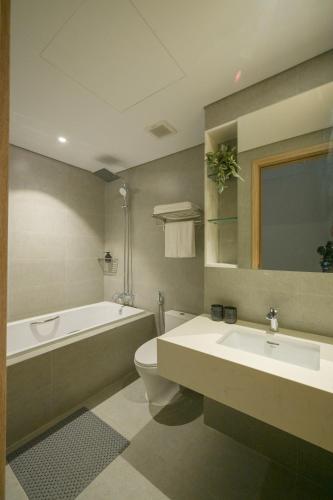 a bathroom with a tub and a toilet and a sink at TS Apartment in Hanoi