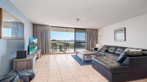 a living room with a couch and a flat screen tv at Gemini Resort 55 Stunning Ocean Views in Golden Beach