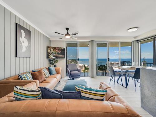 a living room with a couch and a table with a dining room at Aurora Pacific Unit 12 in Caloundra