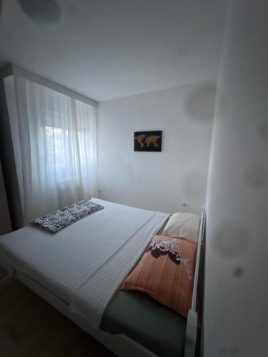 a bed in a white room with a window at Volga in Herceg-Novi