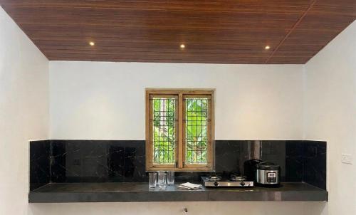 a kitchen with a black counter and a window at Lotus Green Hotel And Restaurant in Arugam Bay