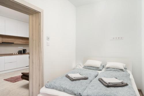 a bedroom with a bed with towels on it at DowntownKate in Debrecen
