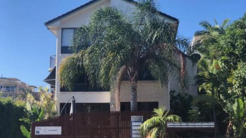 a house with a palm tree in front of it at Beachside Court Unit 9 in Caloundra