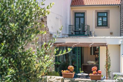 a house with two potted plants in front of it at GuestReady - Jardim das Oliveiras GuestHouse in Porto