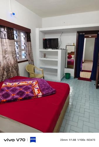 a bedroom with a bed with a red blanket on it at ROYAL budget Rooms in Ooty