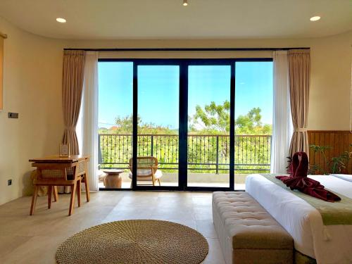 a bedroom with a bed and a large sliding glass door at Twinseas Villa in Uluwatu