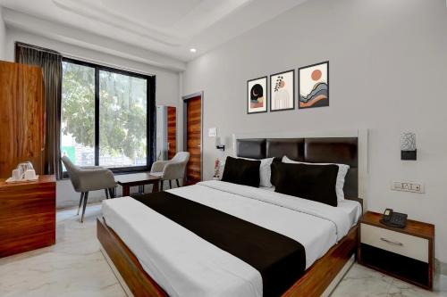 a bedroom with a bed and a desk and a window at Collection O Kharar Bus Terminal Formerly Hotel Kamboj in Kharar