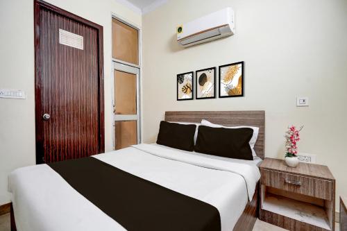 a bedroom with a large white bed with a white and black sheets at Hotel O Railway Station Road Formerly Alwar Delight in Alwar